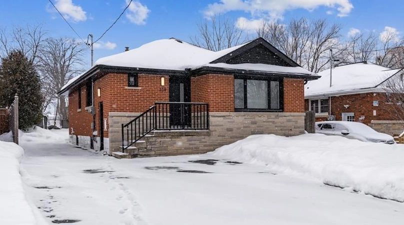 Snow-covered brick and stone bungalow